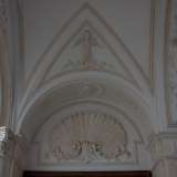 Dei bassorilievi rappresentanti conchiglie adornano le lunette degli accessi arcuati mentre sulla volta, figure di angeli in stucco accolgono i visitatori